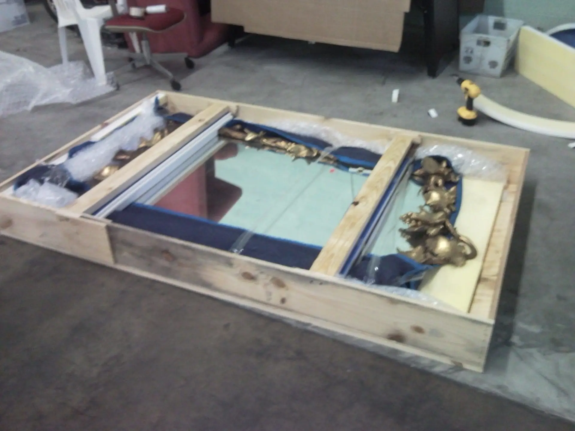 Decorative mirrored panel supported within an open wooden frame.