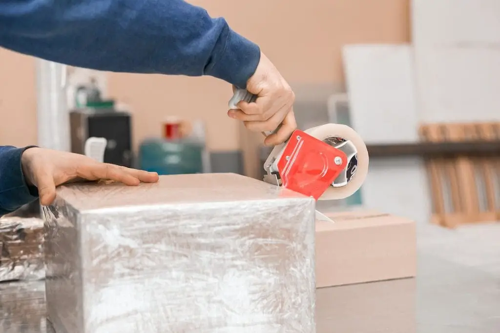 Sealing a custom crate with packing tape, illustrating secure shipping solutions from Crates of Las Vegas.