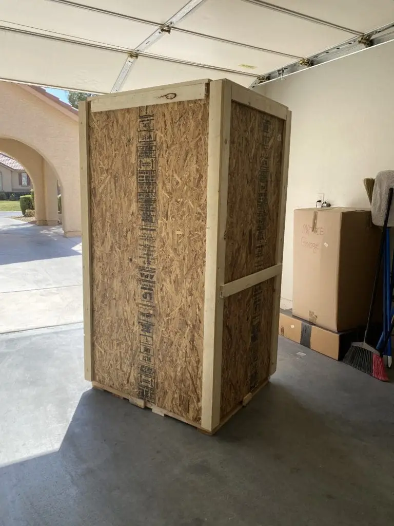 Tall closed wood crate standing inside a garage