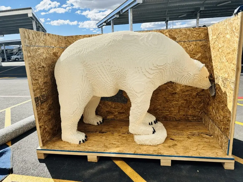 White polar bear sculpture inside an open wooden shipping crate.