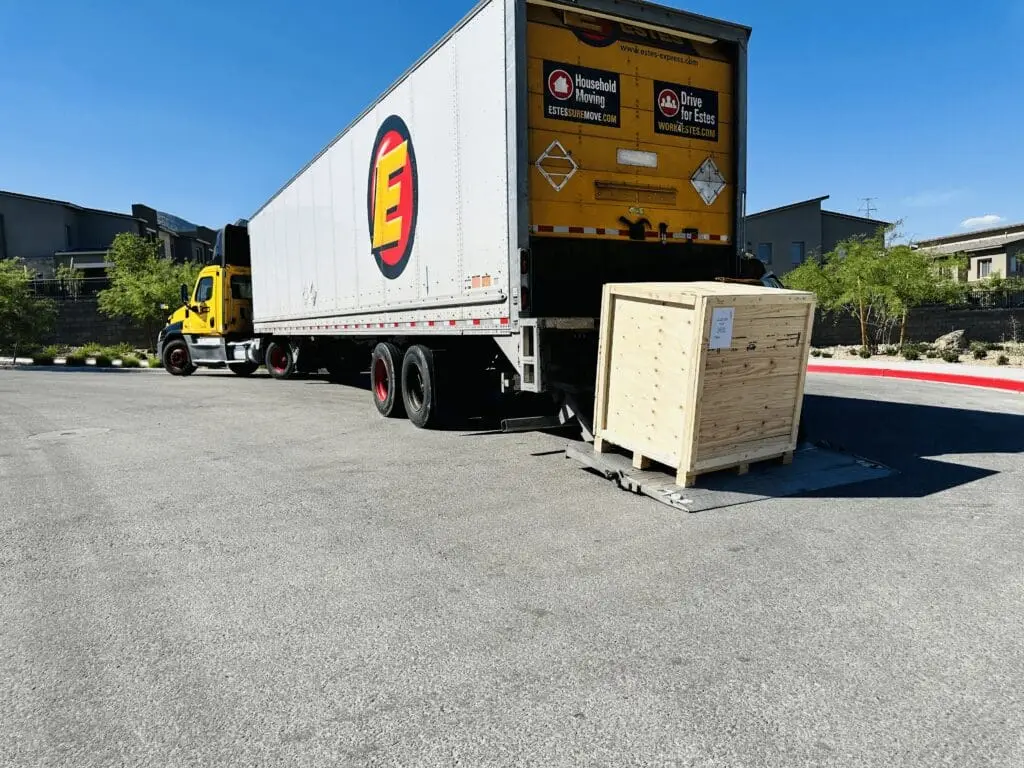 Custom wooden crate and moving truck illustrating safe shipping of fragile goods.