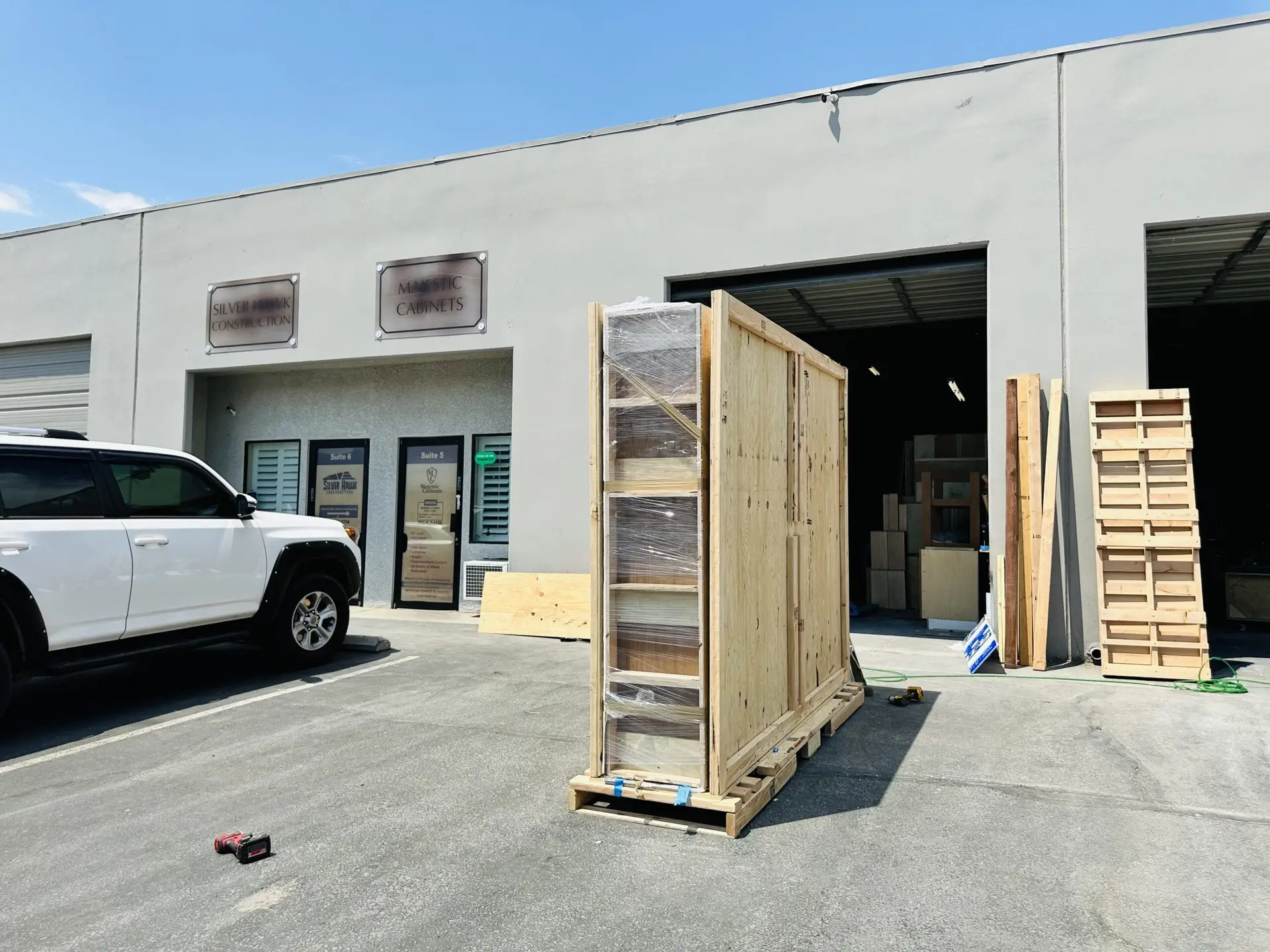 Tall wooden crate standing outside a warehouse entrance.