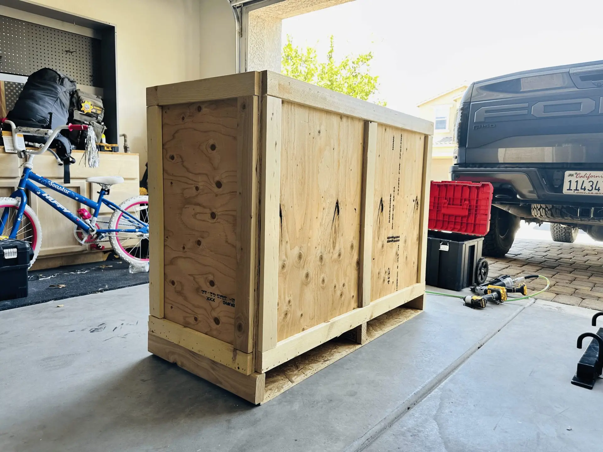 Plywood crate with timber framing inside a garage.