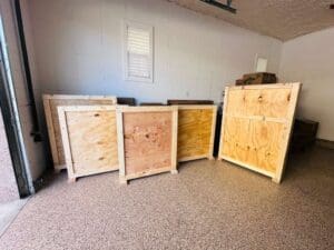 Custom wooden crates displayed in a storage area, showcasing various sizes and designs for secure packaging and shipping solutions.