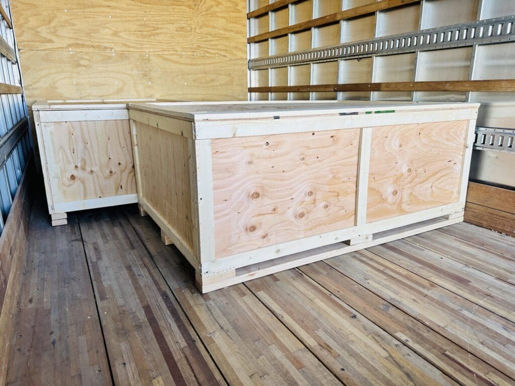 Custom wooden crates for industrial use, showcasing robust construction and designed for secure transport of heavy equipment, inside a truck.